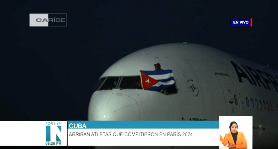 López, único atleta en el mundo en lograr cinco preseas doradas en ediciones consecutivas en una disciplina individual, sacó sus 130 kilogramos de peso por la ventanilla, a la diestra del capitán de la nave, para ondear la enseña nacional.
